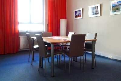 Ansicht des Konferenz-Raums bei mira, ausgestattet mit Tisch, Stühlen, freundlichem Licht und warmer Atmosphäre – ideal zu mieten für Sitzungen und Besprechungen.