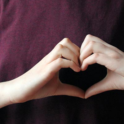 Zwei Hände formen ein Herz.